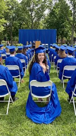 Photo 2: the daughter turning in her seat among the graduates to wave