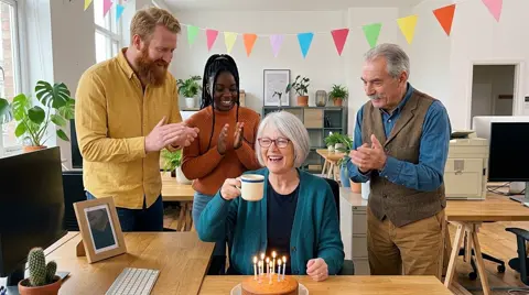 Photo 4: the team clapping around her desk as she raises her mug